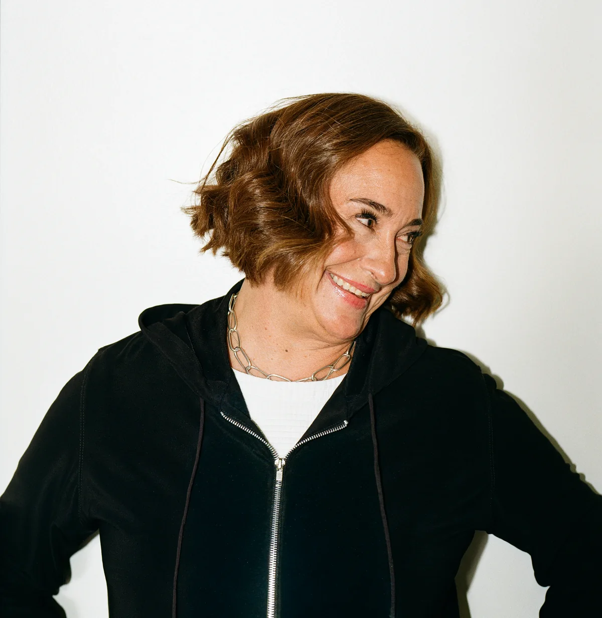 Jennifer laughing in a black zip hoodie