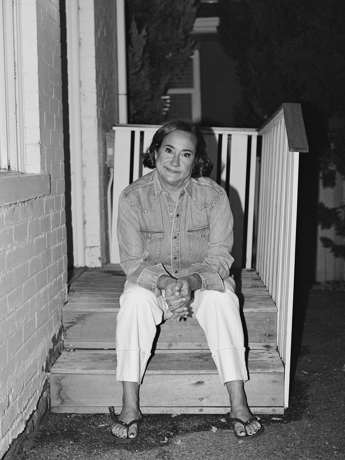 Jennifer sitting on porch steps in a black-and-white film photograph