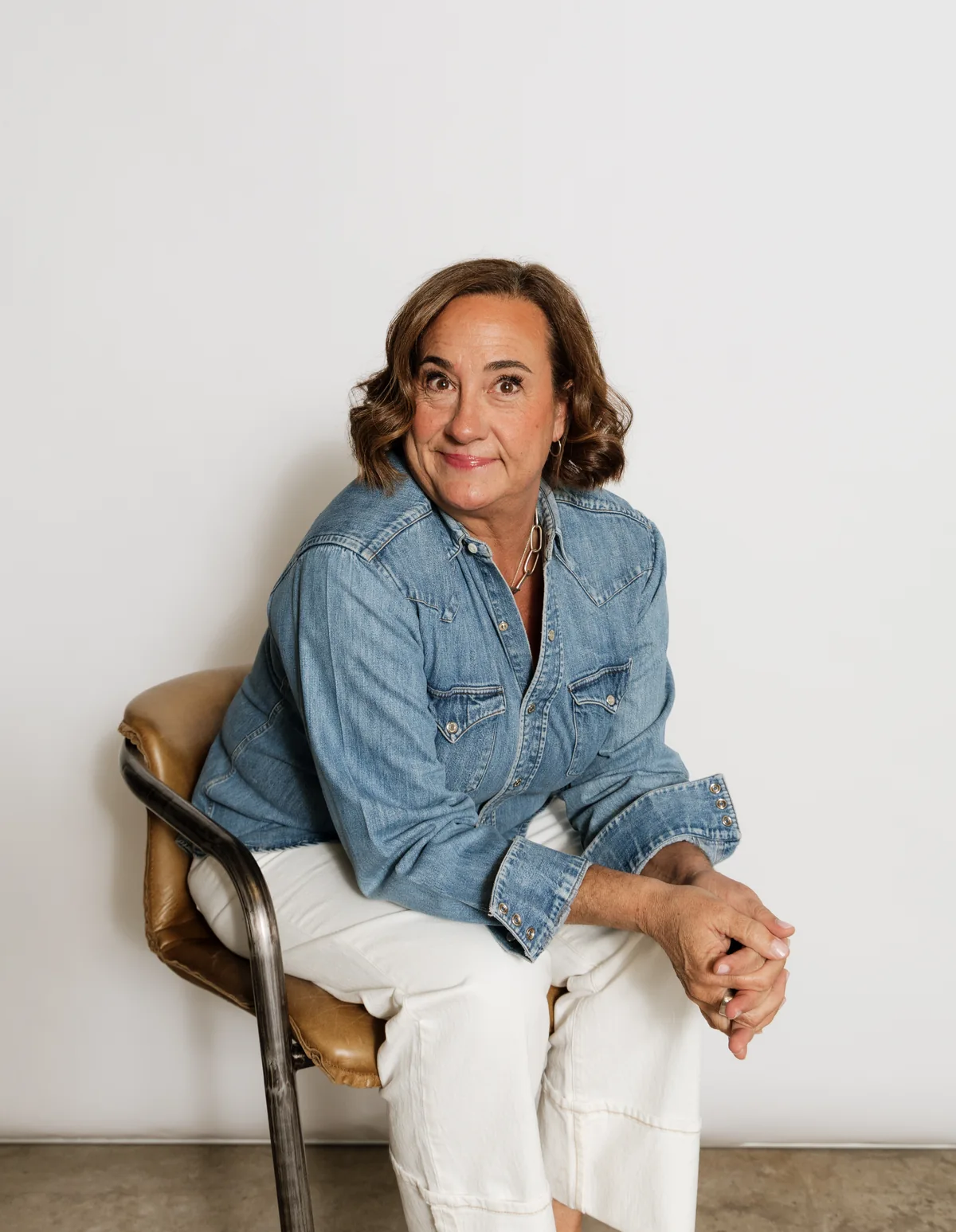 Jennifer Berger, seated in a denim shirt, smiling at the camera