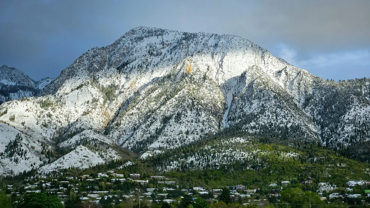 A snow-dusted peak above a Salt Lake residential area